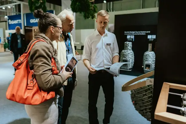 Visitors exploring new technology with an exhibitor at an innovation fair